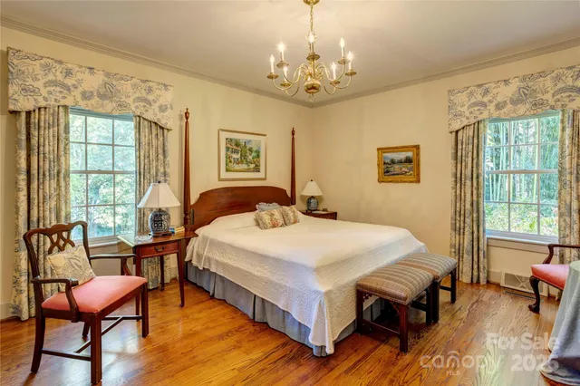 a spacious bedroom with a bed and a table chair