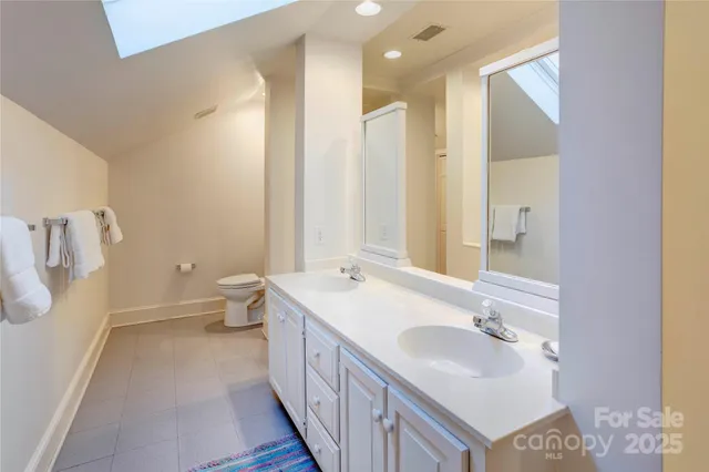 a bathroom with a double vanity sink mirror and toilet