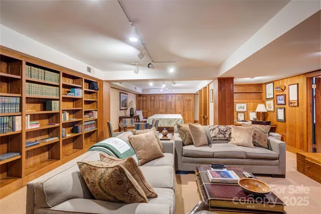 a living room with furniture and a book shelf