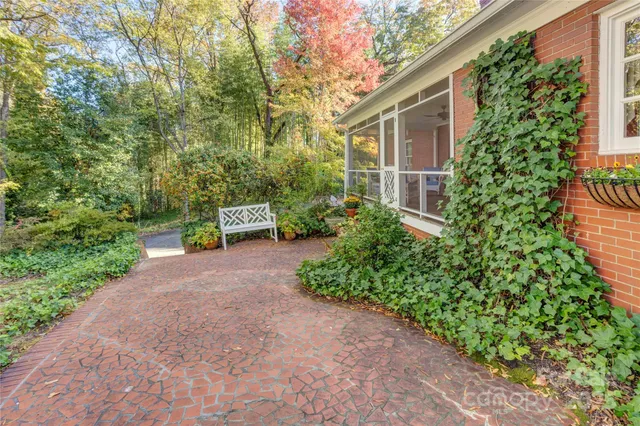 a front view of a house with a yard and potted plants