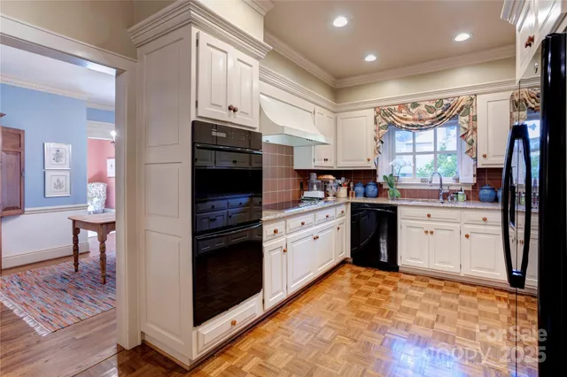 a kitchen with granite countertop a refrigerator stove top oven and sink
