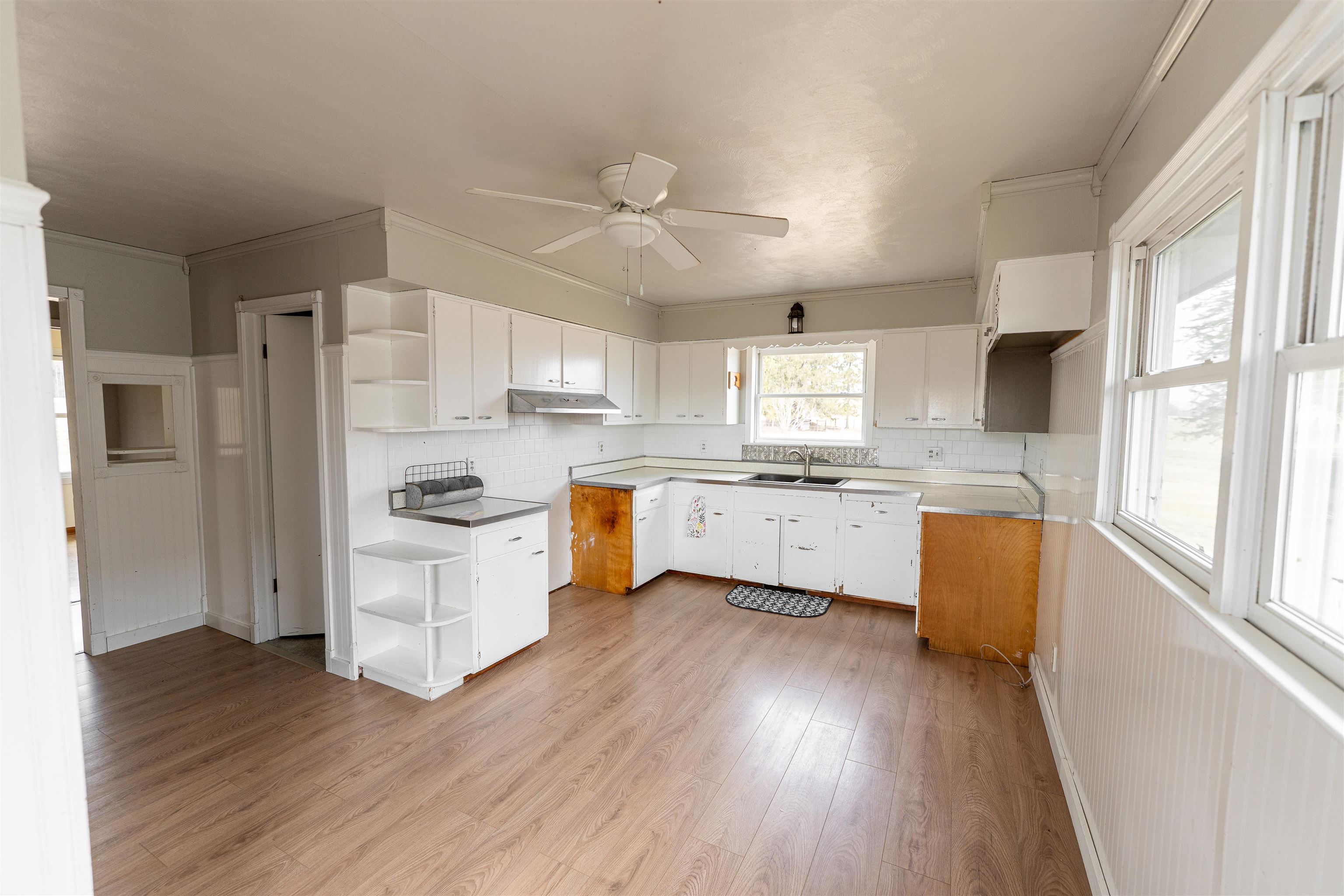 3651 North Brookville Road Forreston, IL 61030 - Photo 10 of 66 a kitchen with a white cabinets a sink a window a wooden floor and stainless steel appliances