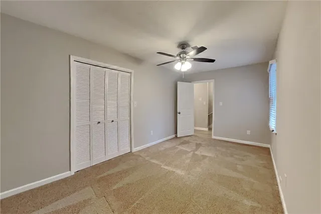 a view of an empty room with a ceiling fan