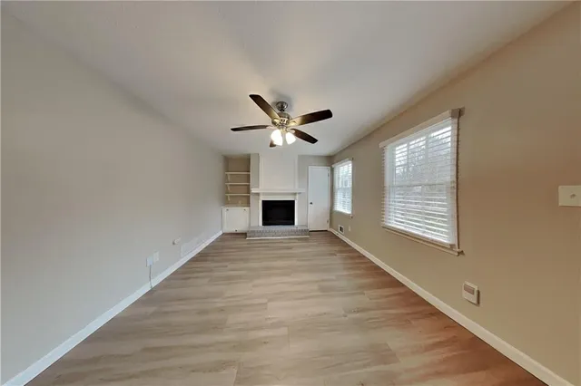 a view of an empty room with a fireplace and a window
