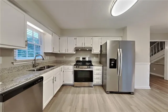 a kitchen with stainless steel appliances granite countertop a stove a sink dishwasher and a refrigerator
