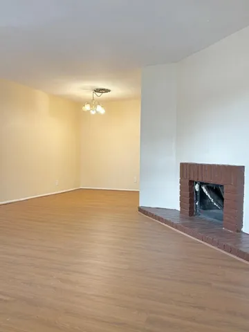 a view of an empty room with a fireplace and a window