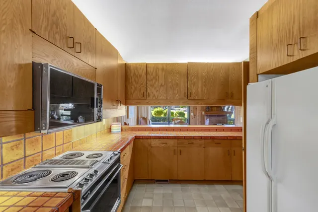 a kitchen with stainless steel appliances granite countertop a refrigerator and a stove