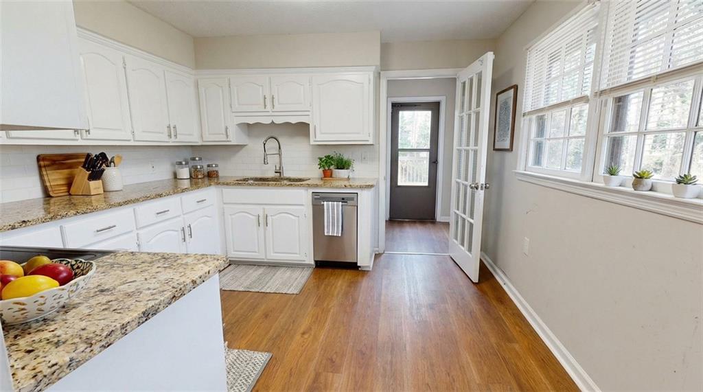 218 East Bonacre Road Cataula, GA 31804 - Photo 12 of 36 a kitchen with a hard wood floor white cabinets and white appliances
