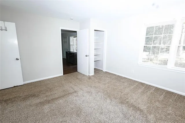 an empty room with windows and closet