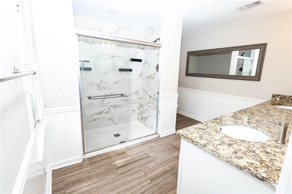 218 East Bonacre Road Cataula, GA 31804 - Photo 21 of 36 a bathroom with a granite countertop mirror and a shower