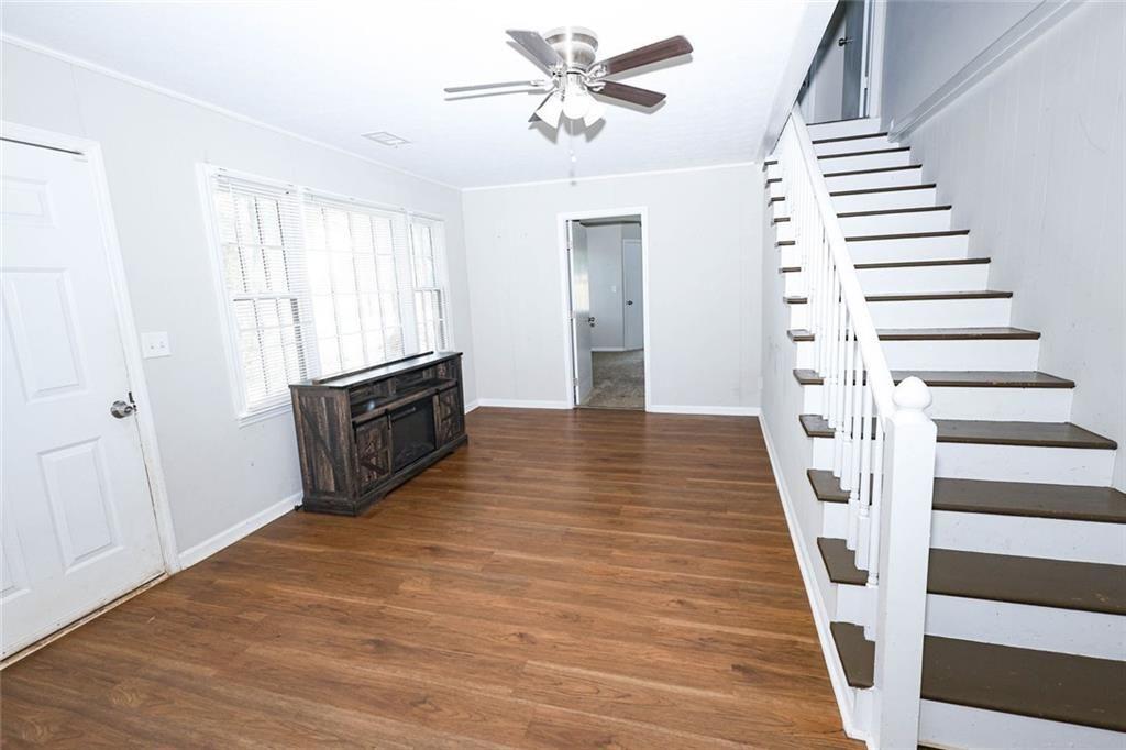218 East Bonacre Road Cataula, GA 31804 - Photo 9 of 36 a view of a livingroom with wooden floor stairs and a ceiling fan