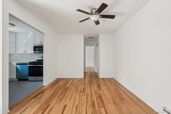 a view of empty room with wooden floor and window