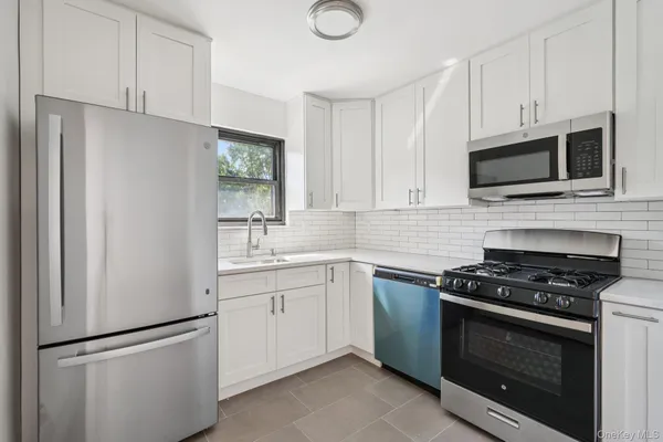a kitchen with cabinets stainless steel appliances and a sink
