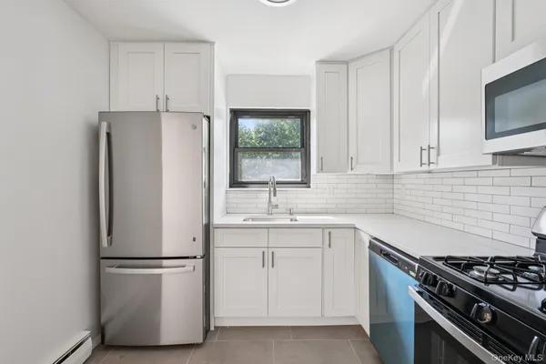 a kitchen with white cabinets and white appliances
