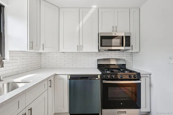 a kitchen with cabinets stainless steel appliances and a sink