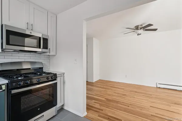 a kitchen with granite countertop cabinets stainless steel appliances and wooden floor