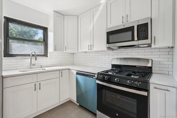a kitchen with cabinets stainless steel appliances and a sink