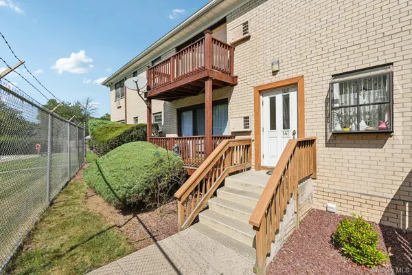 a view of a house with many windows next to a yard