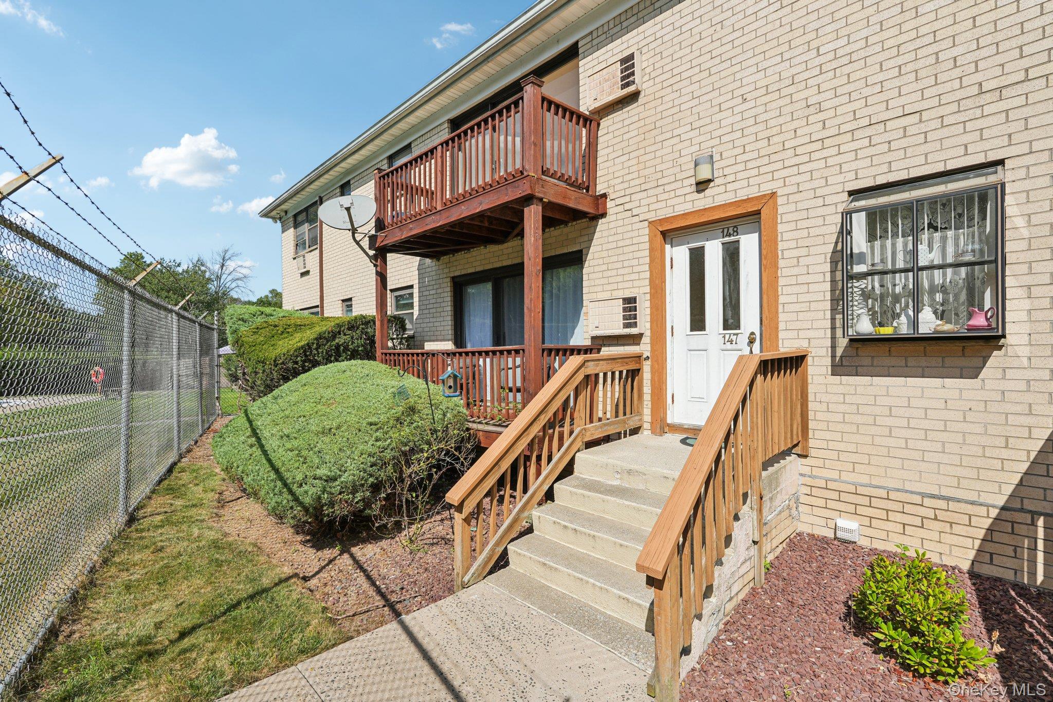 148 Sneden Place West, Unit 148 Spring Valley, NY 10977 - Photo 8 of 37 a view of a house with many windows next to a yard