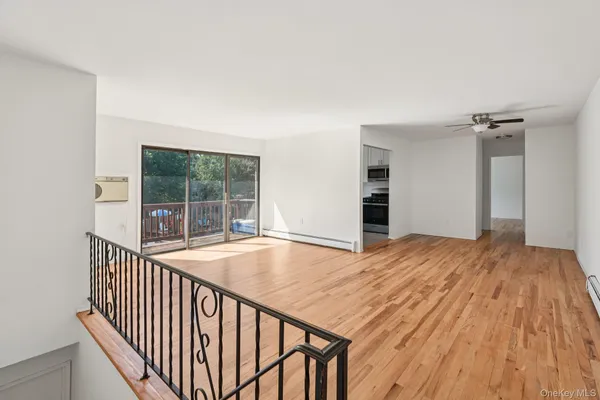 a view of a room with wooden floor and a balcony