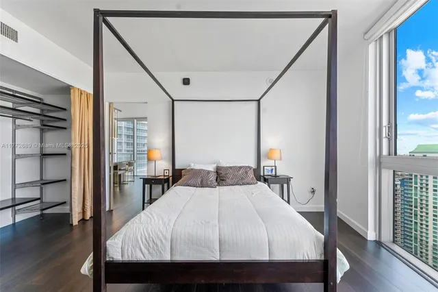 a bedroom with a bed and wooden floor