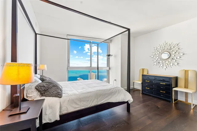 a bedroom with a bed and dresser with mirror