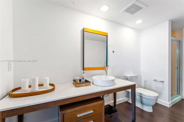 a bathroom with a sink mirror vanity and toilet