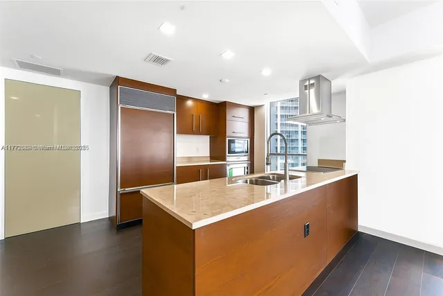 a kitchen with stainless steel appliances granite countertop a sink and a refrigerator
