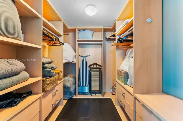 a view of walk in closet with clothes and shoes