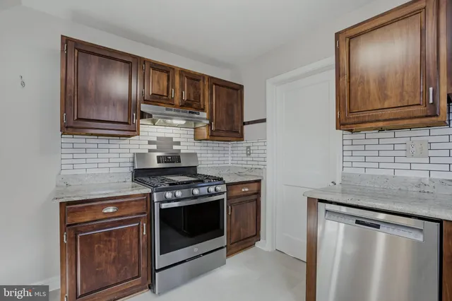 a kitchen with granite countertop wooden cabinets and stainless steel appliances