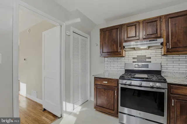 a kitchen with stainless steel appliances wooden cabinets and a stove top oven