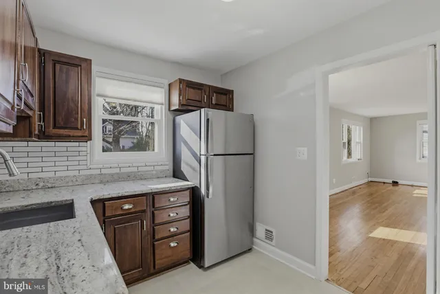 a kitchen with stainless steel appliances granite countertop a refrigerator and a sink