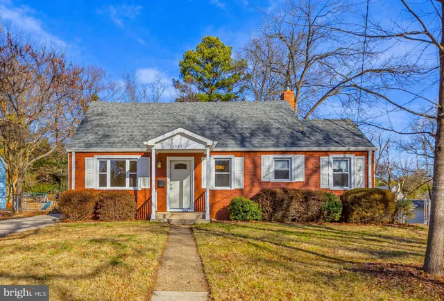 a front view of house with yard and trees around