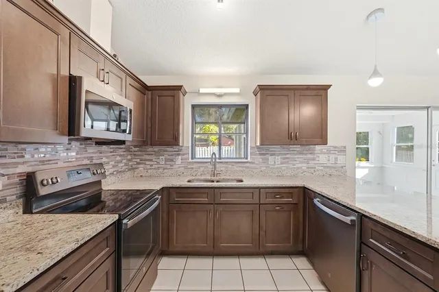 a kitchen with stainless steel appliances granite countertop a refrigerator and a stove