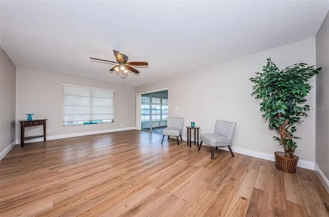 a dining room with wooden floor a chandelier a glass table and chairs