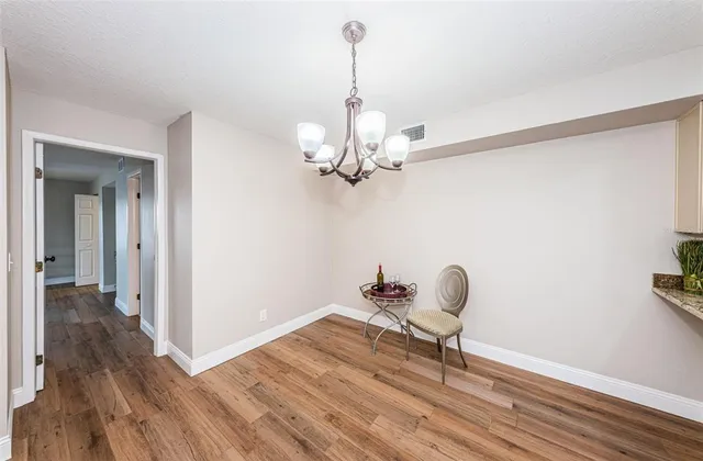 a room with white cabinets and wooden floor