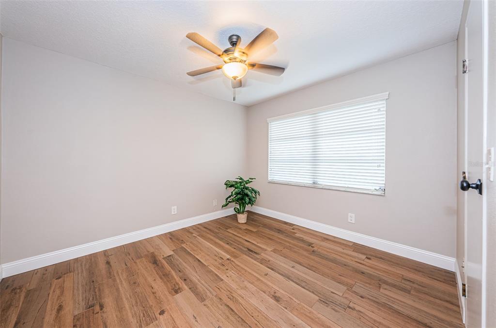 5157 Silent Loop, Unit 301 New Port Richey, FL 34652 - Photo 36 of 71 an empty room with wooden floor fan and windows