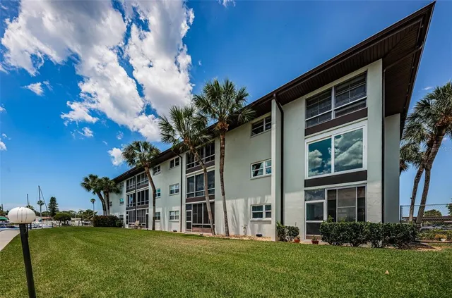 a kitchen with stainless steel appliances kitchen island granite countertop a table chairs in it and wooden floors