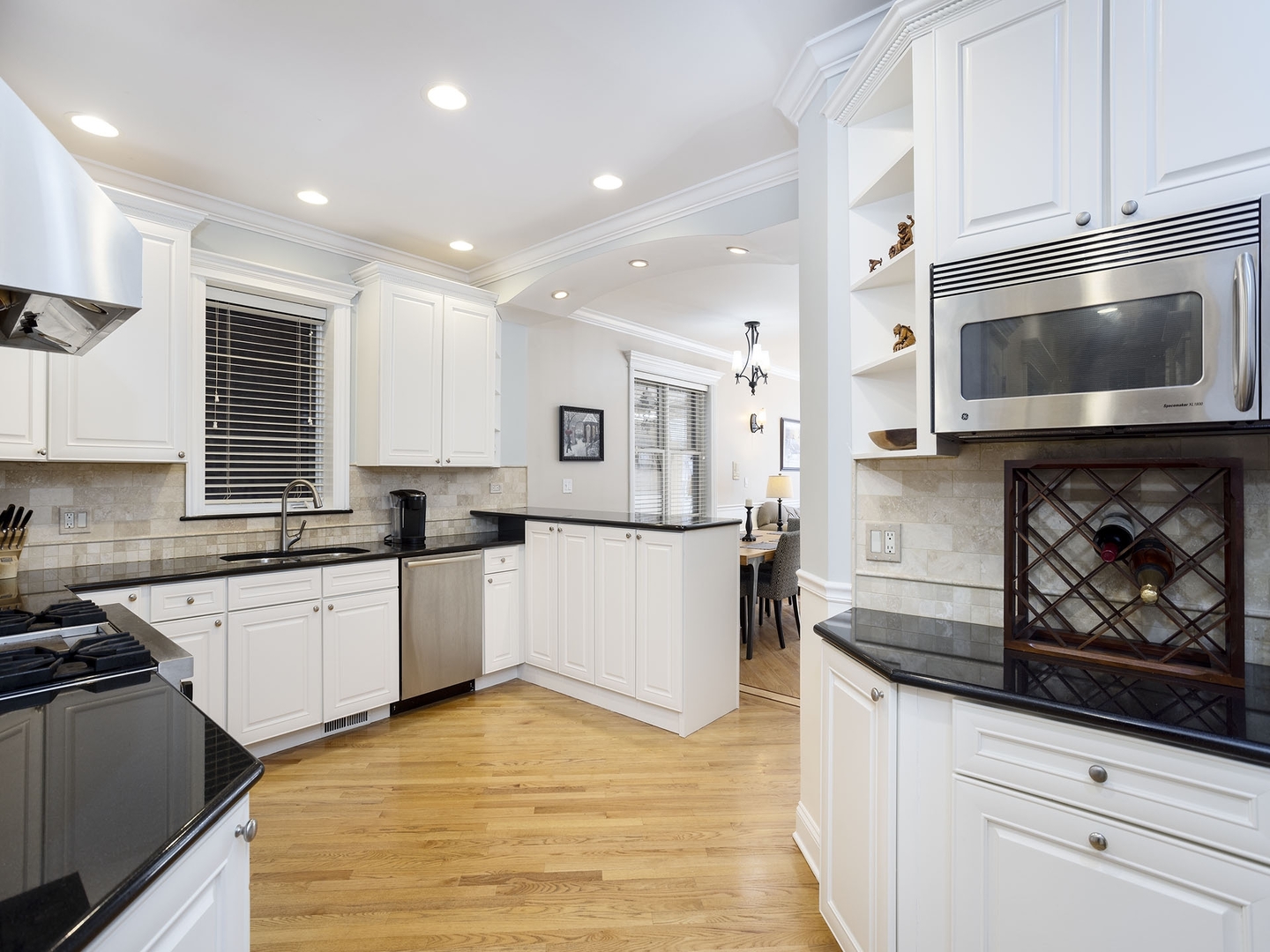 910 West Roscoe Street, Unit 1 Chicago, IL 60657 - Photo 9 of 13 a kitchen with stainless steel appliances granite countertop a stove a sink and a microwave