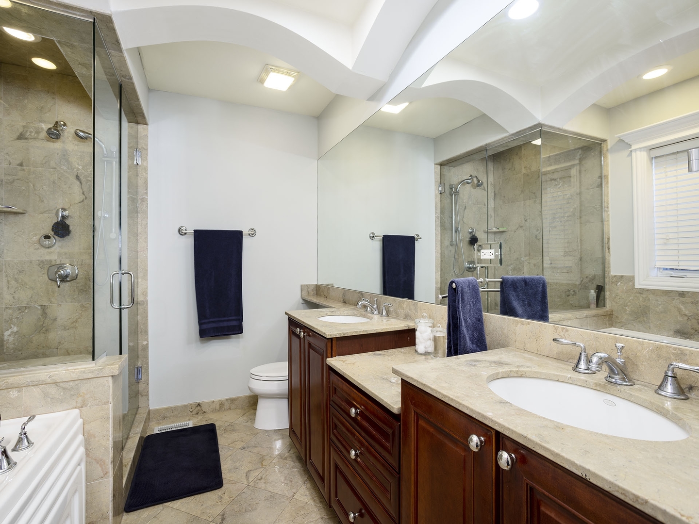 910 West Roscoe Street, Unit 1 Chicago, IL 60657 - Photo 10 of 13 a spacious bathroom with a double vanity sink toilet and shower