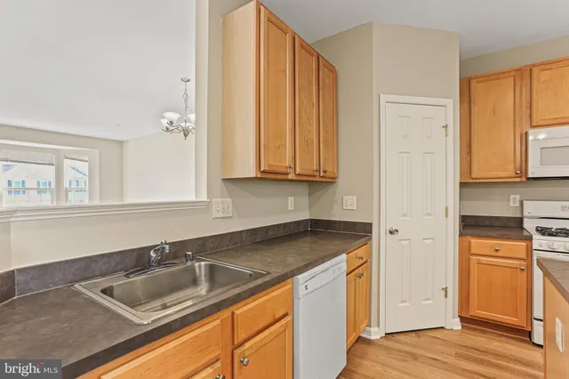 a kitchen with granite countertop a sink stove and cabinets
