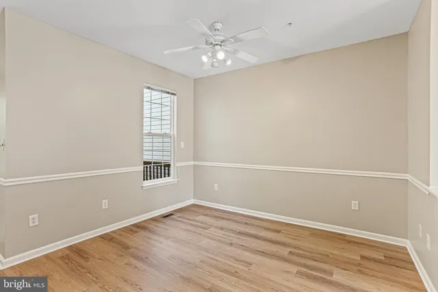 an empty room with a window and a ceiling fan