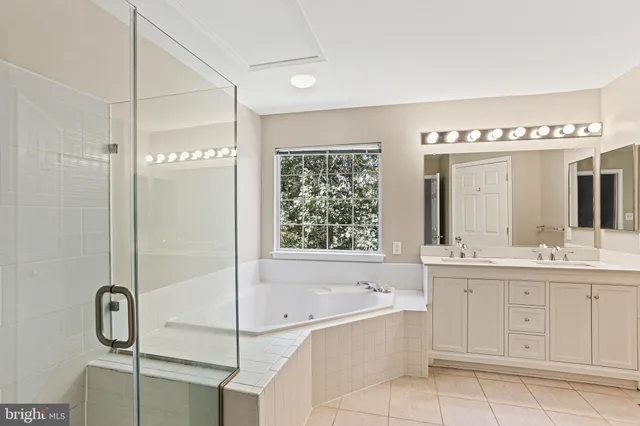 a bathroom with a tub sink and mirror