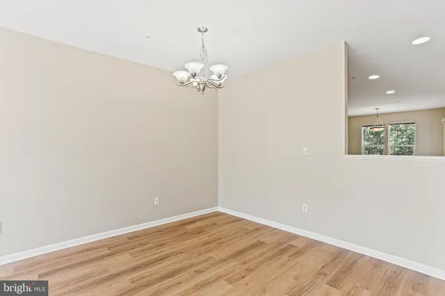 a view of a room with wooden floor and chandelier