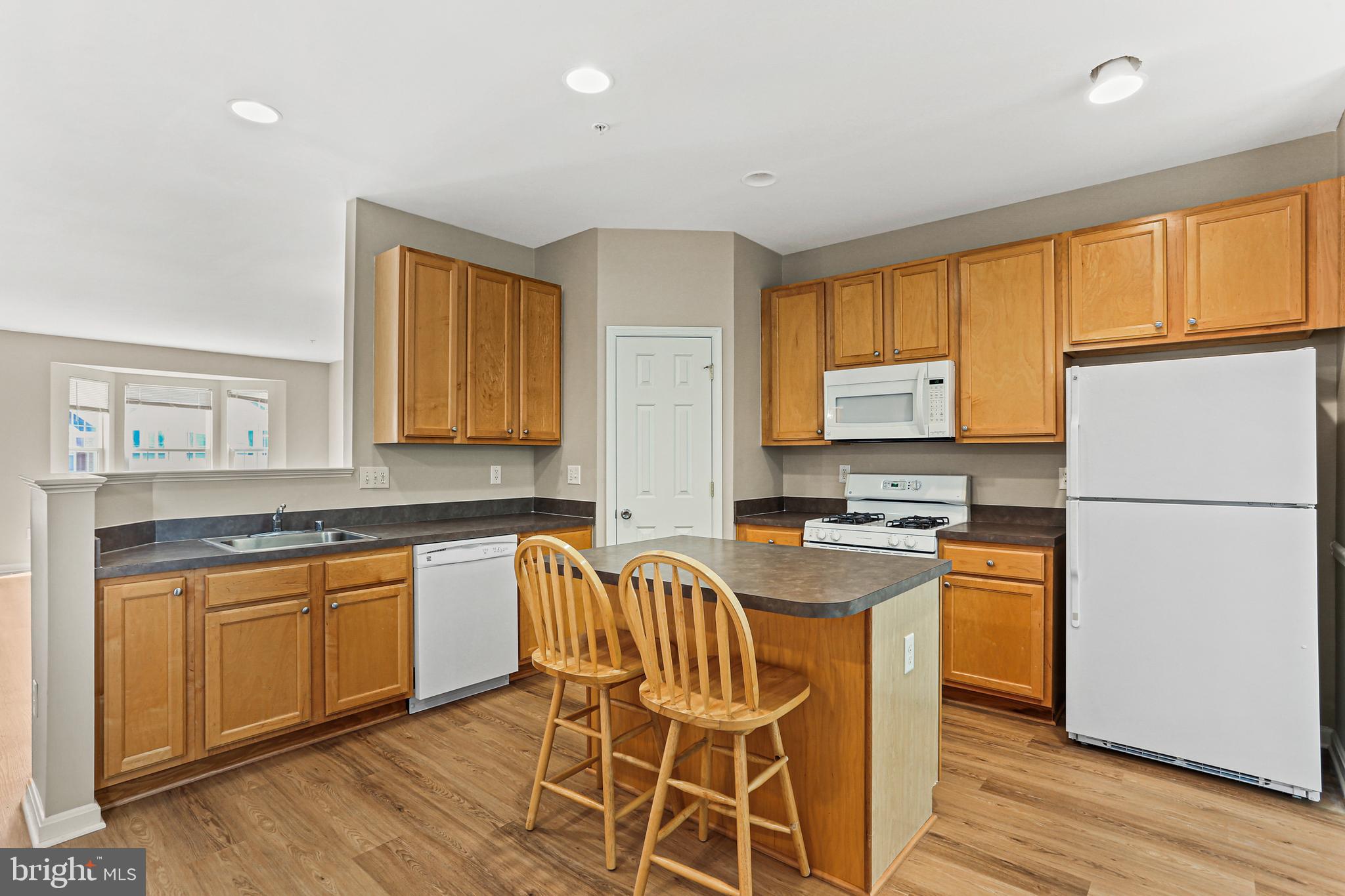 804 Patuxent Run Circle Odenton, MD 21113 - Photo 10 of 29 a kitchen with stainless steel appliances granite countertop a stove a sink a refrigerator white cabinets and wooden floor