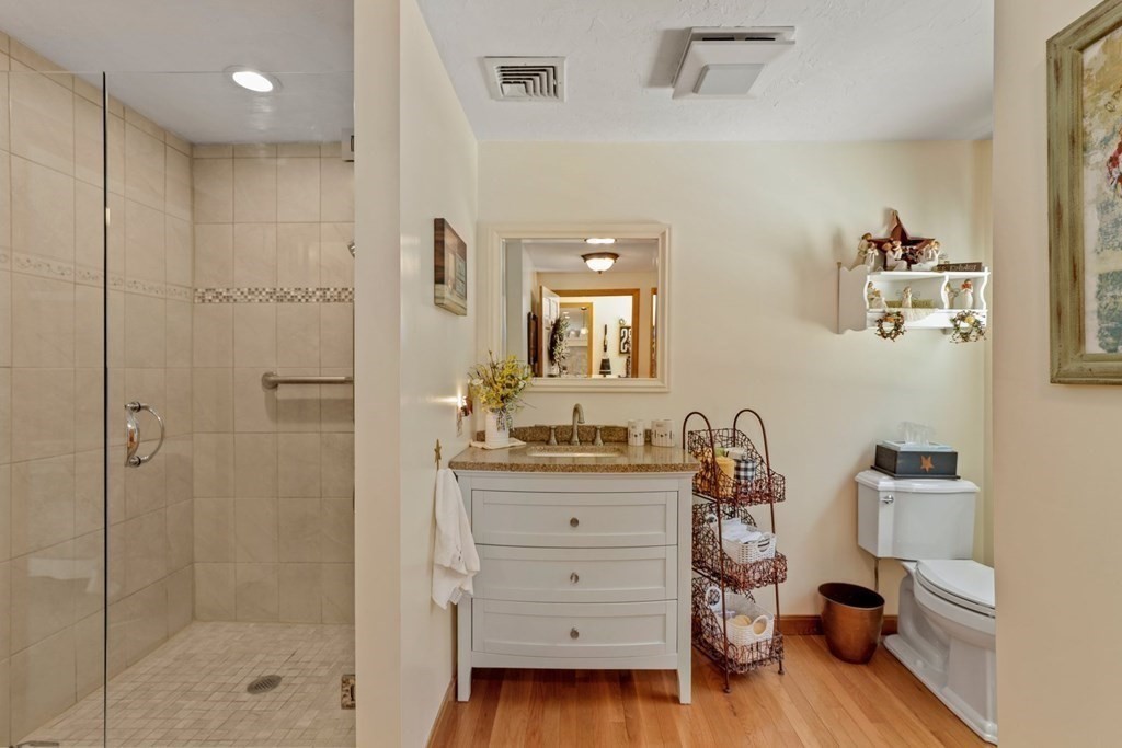 10 Quail Run Road Bellingham, MA 02019 - Photo 15 of 40 a bathroom with a granite countertop sink a toilet a mirror and shower