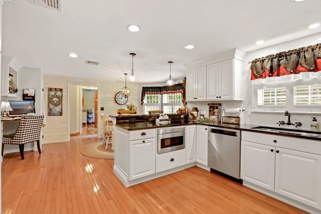 10 Quail Run Road Bellingham, MA 02019 - Photo 3 of 40 a kitchen with stainless steel appliances granite countertop a stove top oven a sink dishwasher and white cabinets with wooden floor