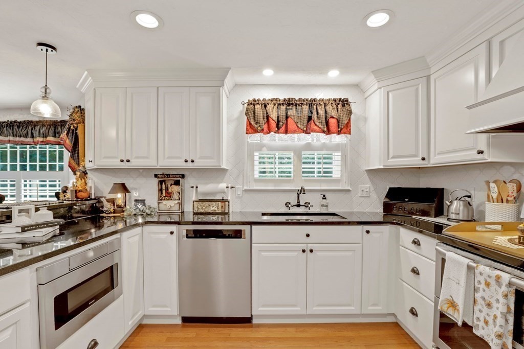 10 Quail Run Road Bellingham, MA 02019 - Photo 4 of 40 a kitchen with stainless steel appliances granite countertop a stove a sink and white cabinets