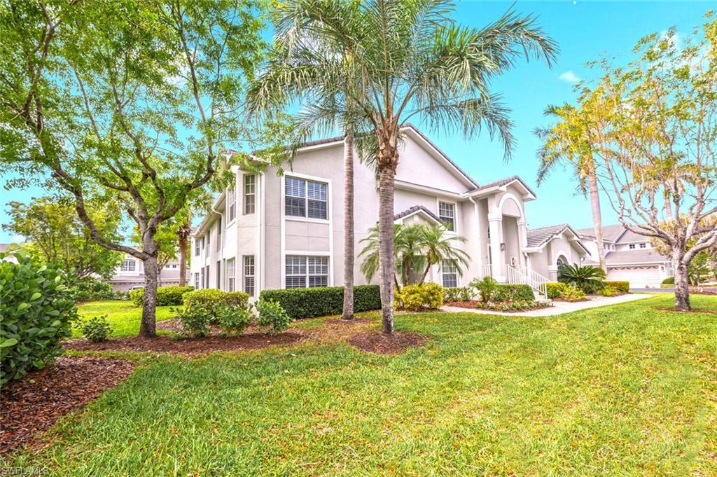 7005 Pinnacle Lane, Unit 1501 Naples, FL 34110 - Photo 1 of 46 a front view of a house with garden