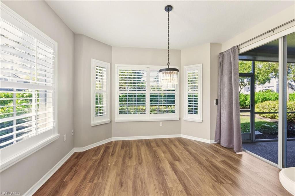 7005 Pinnacle Lane, Unit 1501 Naples, FL 34110 - Photo 13 of 46 a view of an empty room with wooden floor and a window